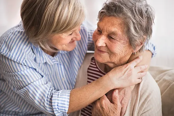 two senior women hugging