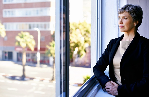 businesswoman looking out of an office window