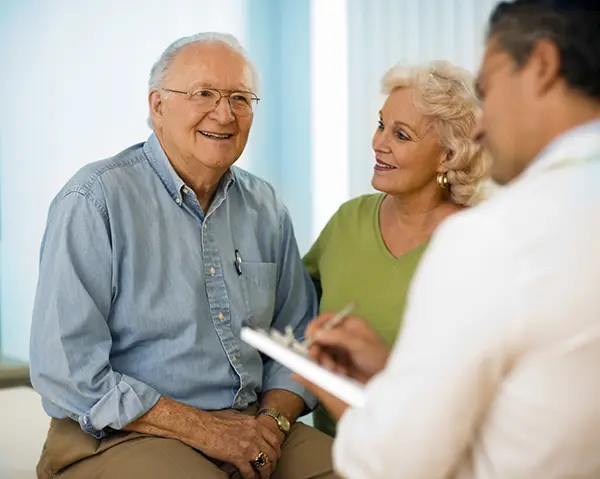 Senior couple talking with doctor.