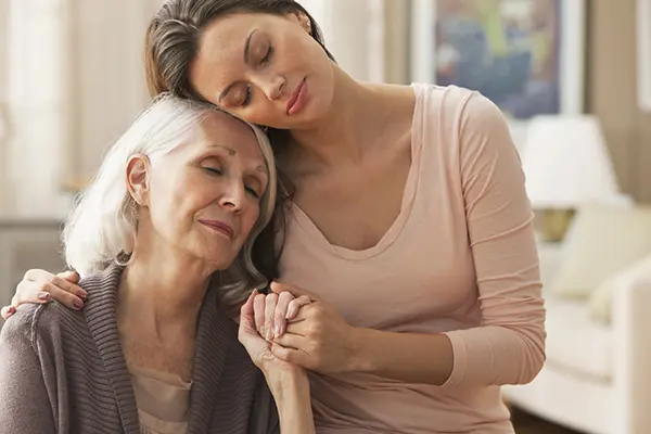 Daughter comforting senior mother