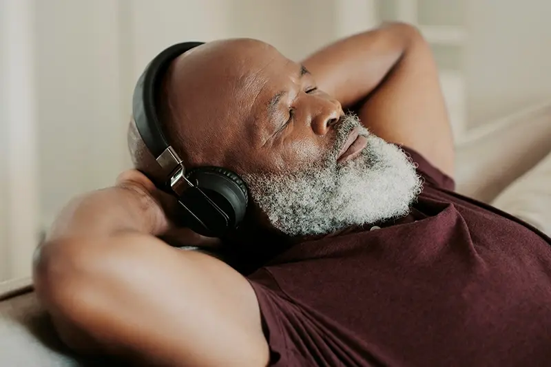 senior man relaxing and listening to headphones