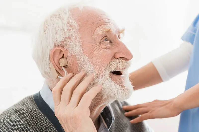 happy senior man wearing hearing aid