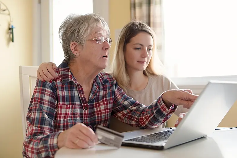 senior woman with her daughter online purchasing together